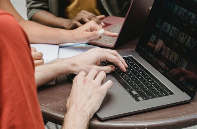 human hands on a computer, typing.